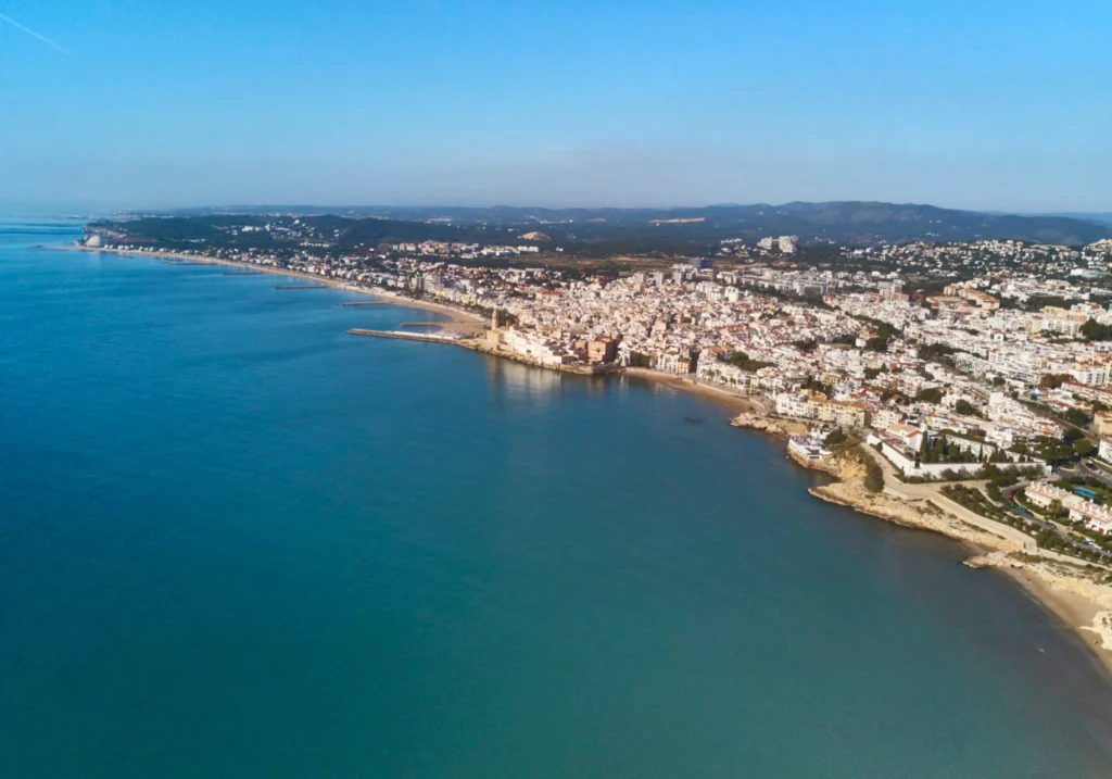 Aerial view of Sitges and its coastline with beaches and urban development