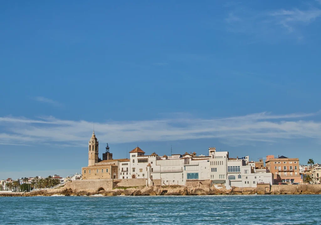View from the sea of Sant Bartomeu church and historic buildings in central Sitges