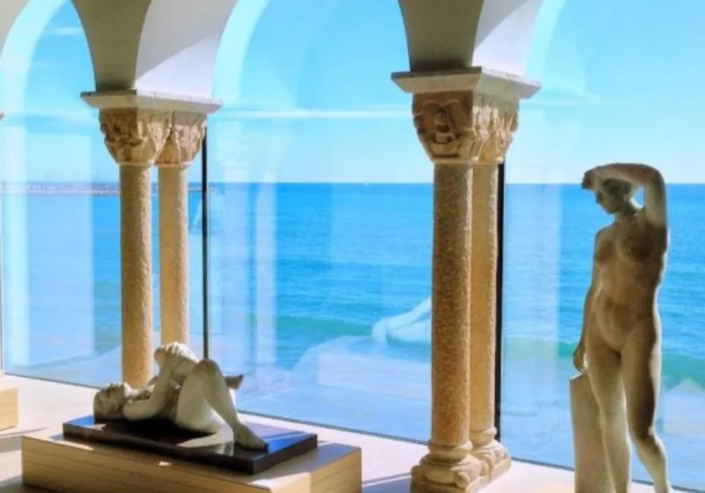 Interior of the Cau Ferrat Museum with sculptures and medieval columns overlooking the sea