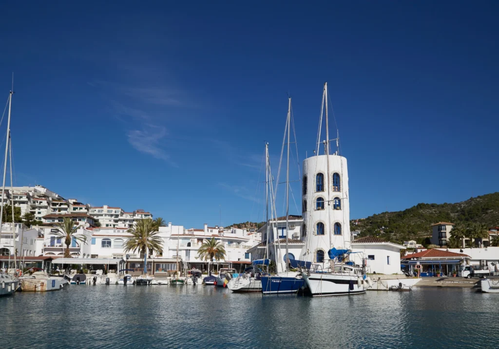 Aiguadolç marina with sailboats and the characteristic white tower under a blue sky