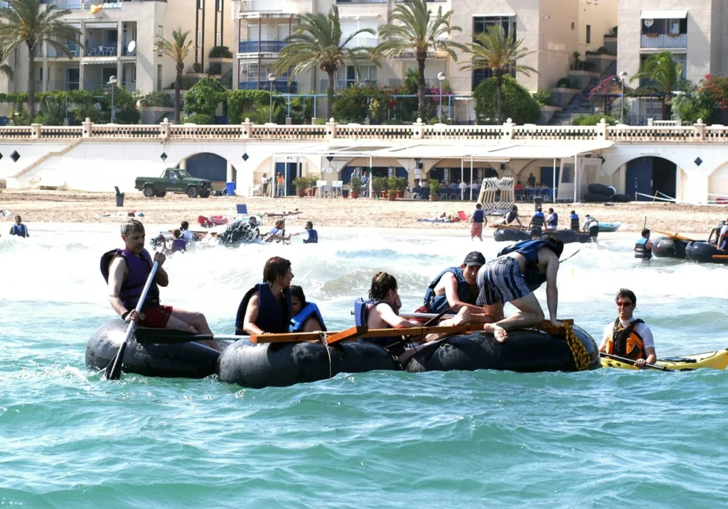 Group of participants navigating on an improvised raft in the sea at Sitges