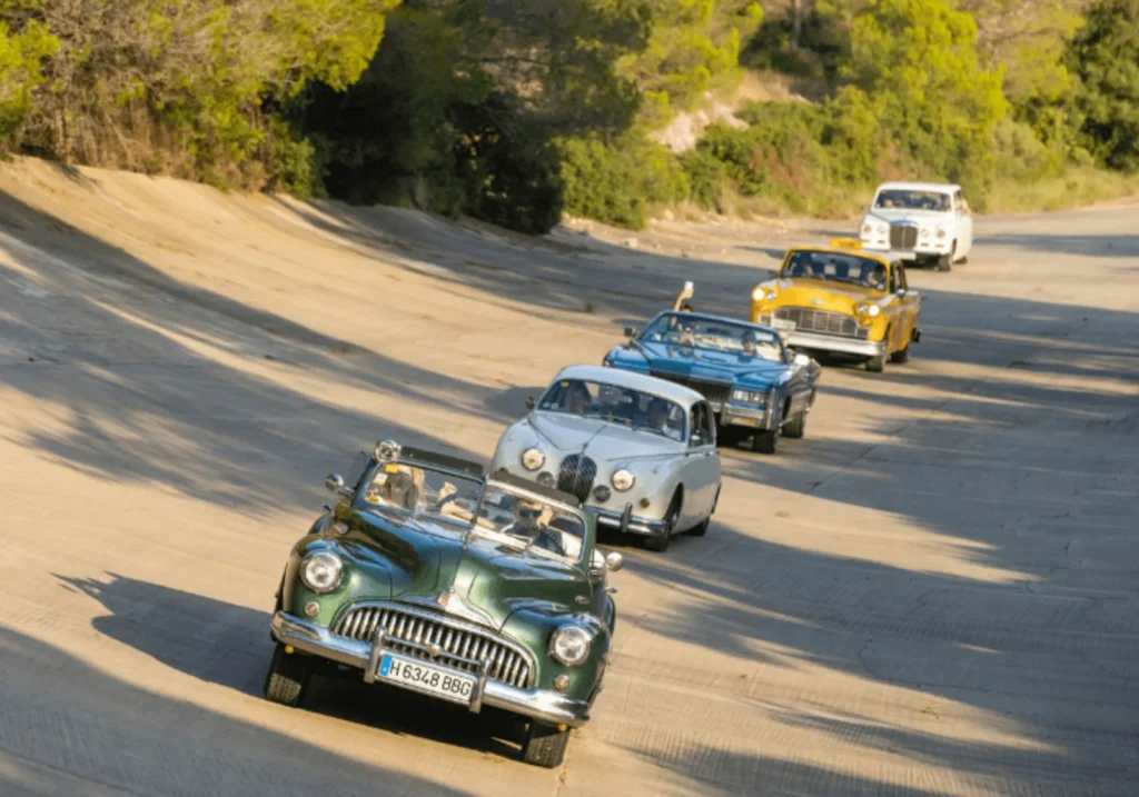 Convoy of classic cars driving in line during an incentive activity near Sitges