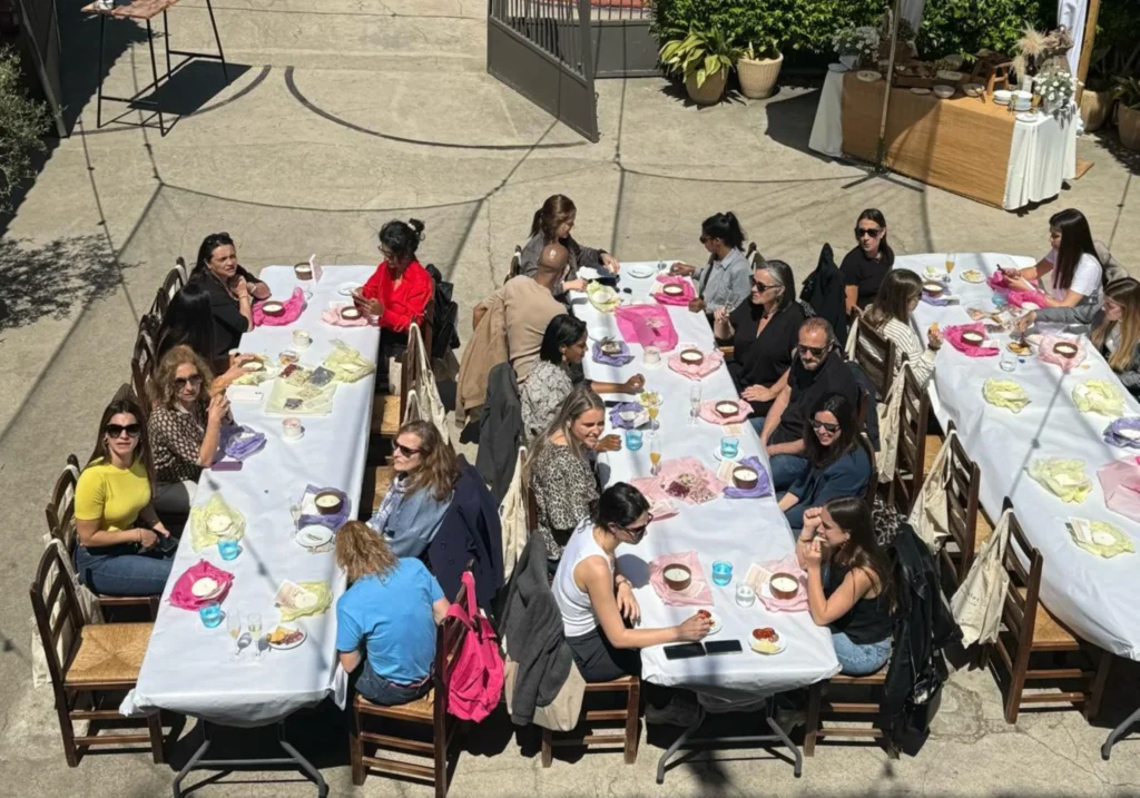 Aerial view of a group lunch at long outdoor tables during a corporate event