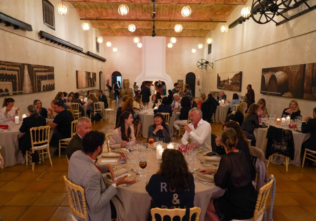 Corporate dinner in a rustic winery with warm lighting and round tables