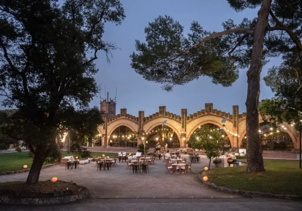 Historic winery exterior with illuminated Gothic arches and tables for an outdoor night event