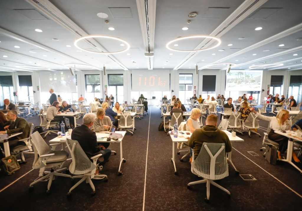 Modern, bright meeting room with professionals working at individual desks