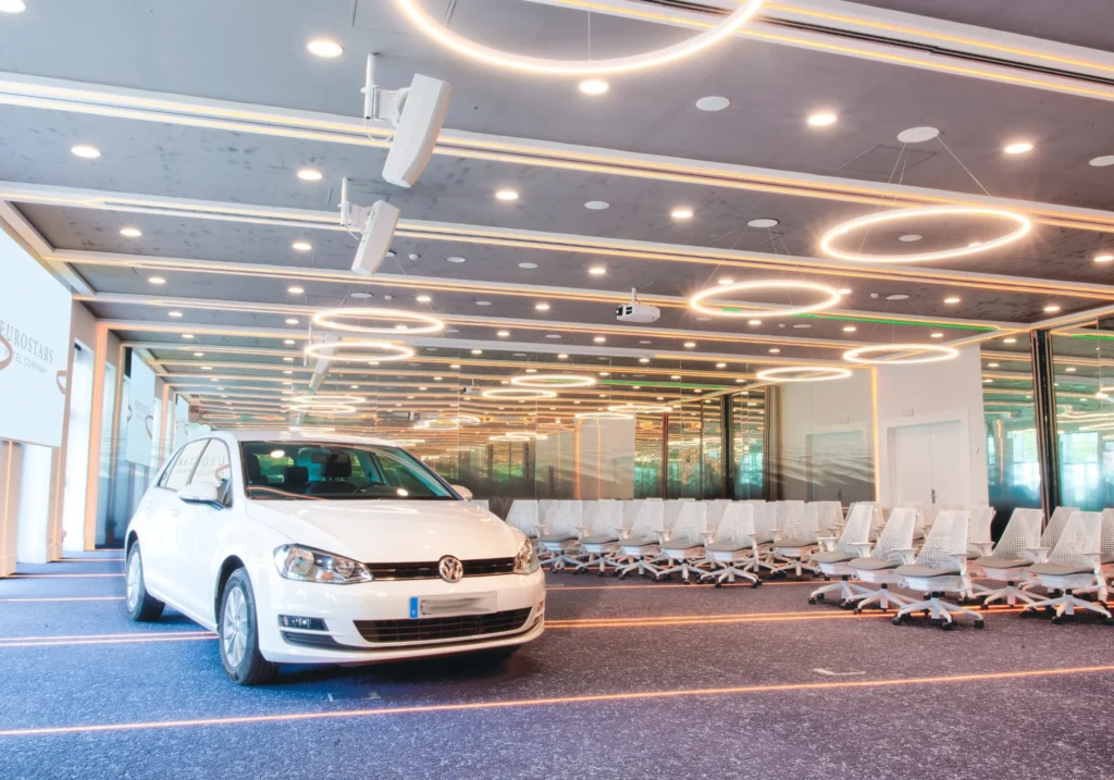 Open event space with a displayed car and white chairs for a product launch